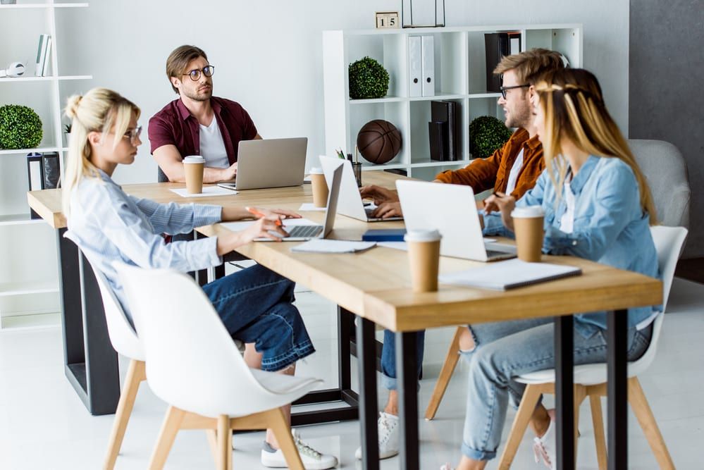 people working together for a startup with their laptops and notebooks