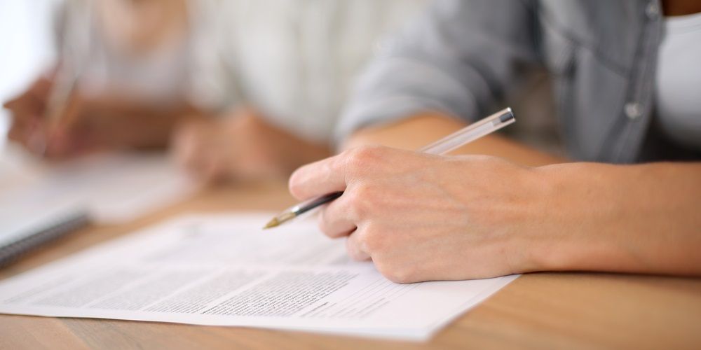 A men with a pen writing on a paper