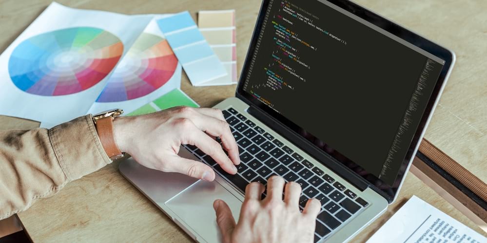 a man writing code in his laptop