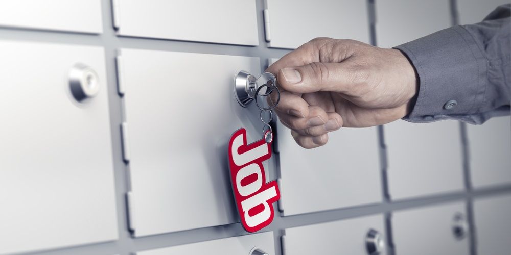 a hand opening a locker with a key chain saying "job"