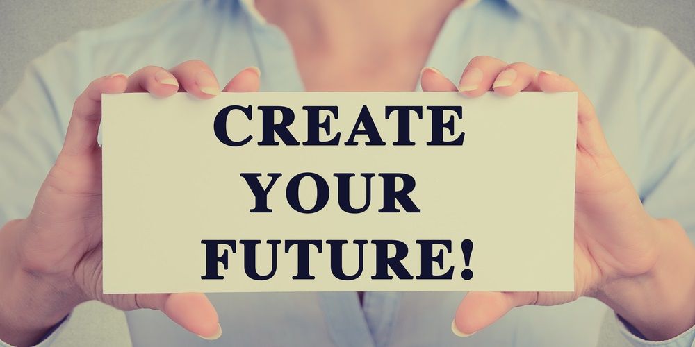 woman's hands holding a cardboard saying "create yuor future"