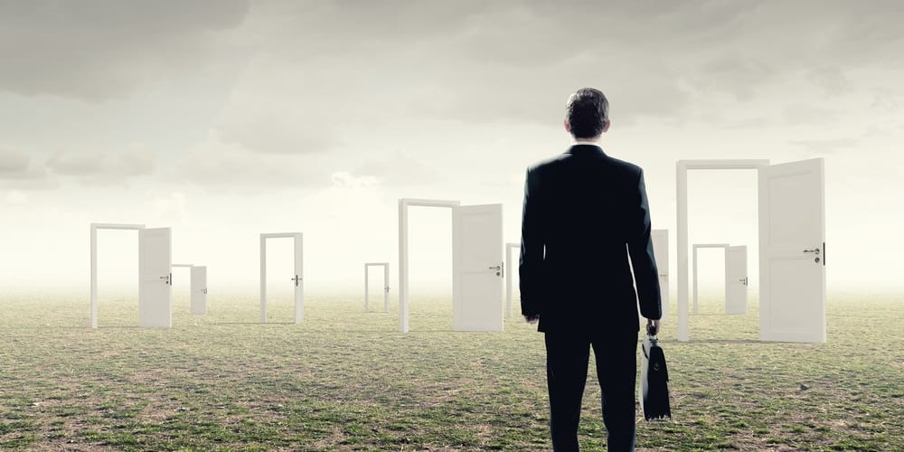 a man with a suit and briefcase on his back looking at different white doors